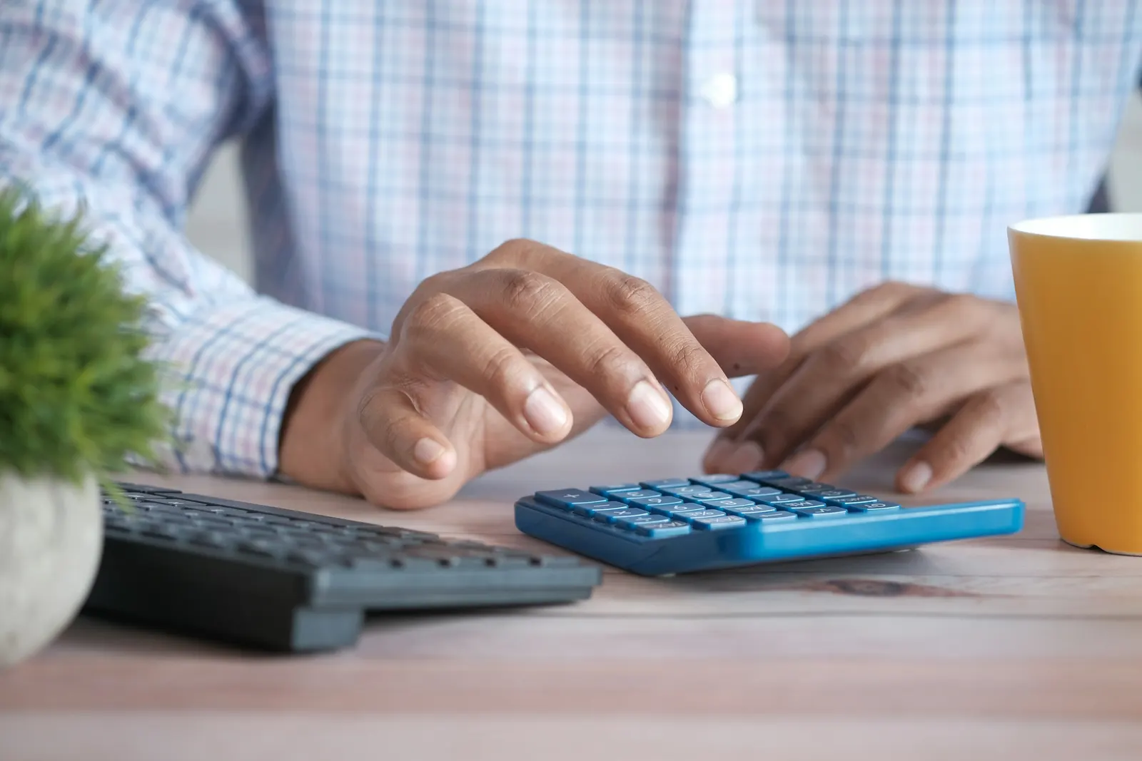 Pay calculations being checked on a calculator at a desk